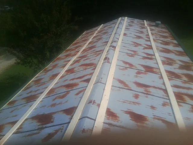 Rusted metal roof panels with new wood purlins before replacement — Storm Damage Roof Repair in Yulee by Roofing Brothers