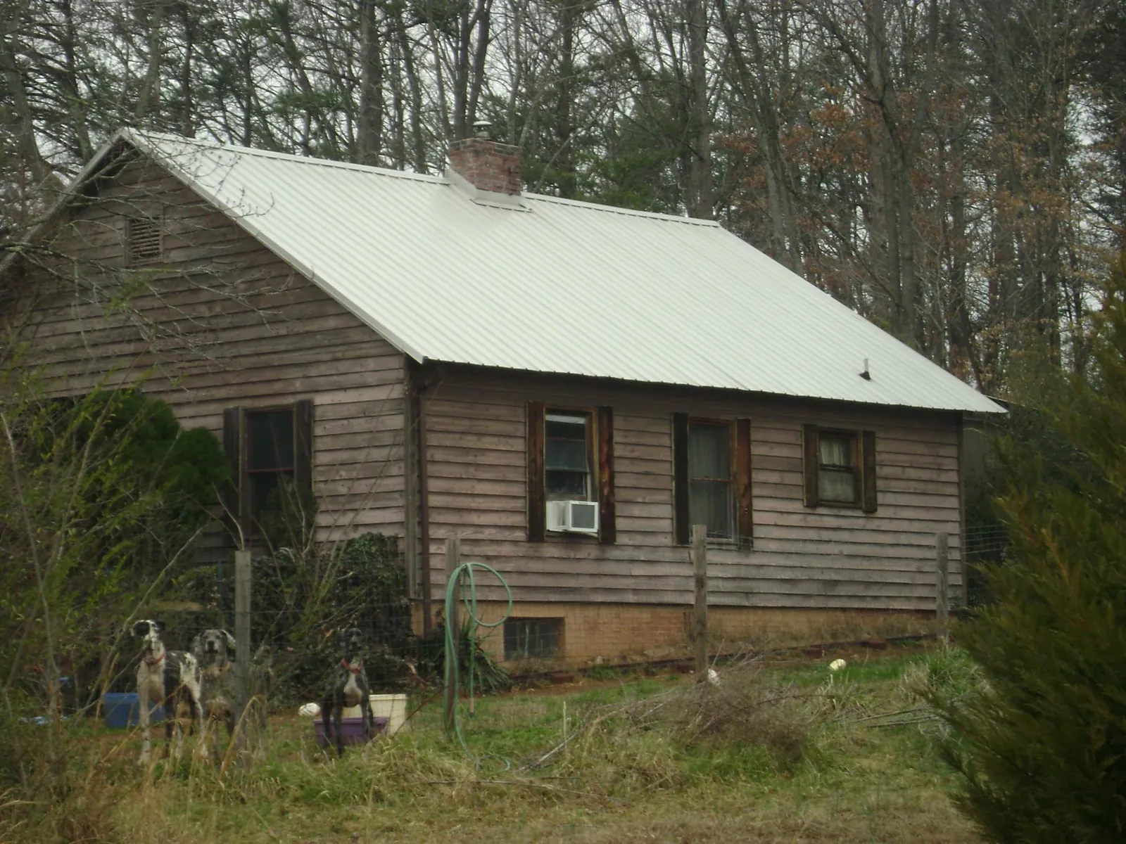 White metal roof on an old wood sided farmhouse, from a Metal Roof Installation job in Yulee